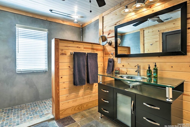 bathroom featuring tile floors, wooden walls, ceiling fan, and vanity