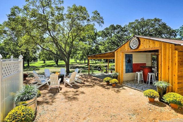 view of yard with an outdoor structure, a fire pit, and a patio