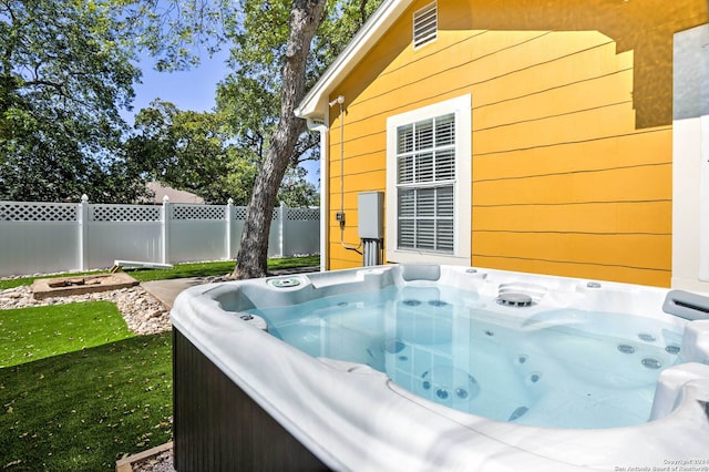 view of swimming pool featuring a hot tub and a yard