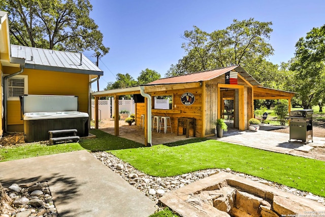 exterior space featuring a yard, a patio area, and a hot tub