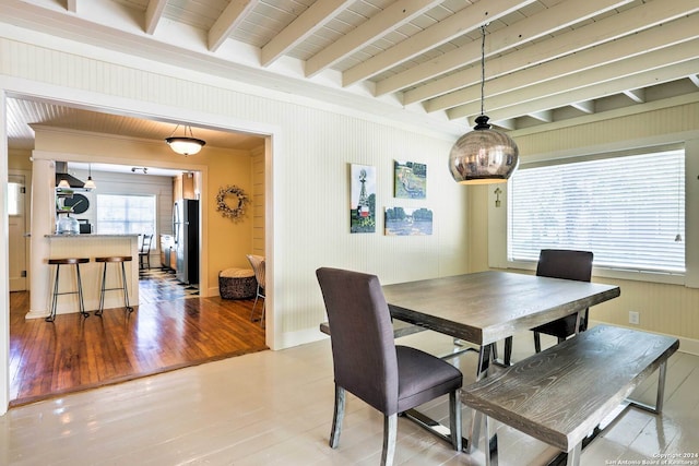 dining room featuring beam ceiling and wood-type flooring