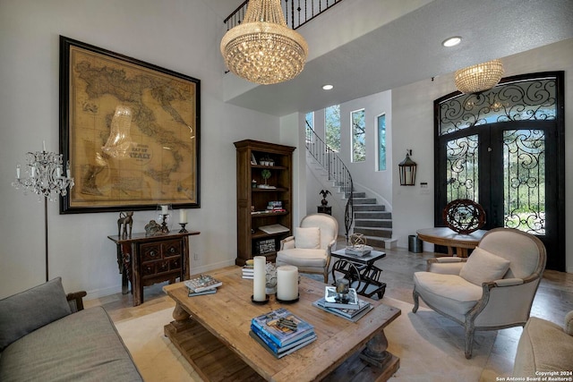 living room featuring a notable chandelier, french doors, and a textured ceiling