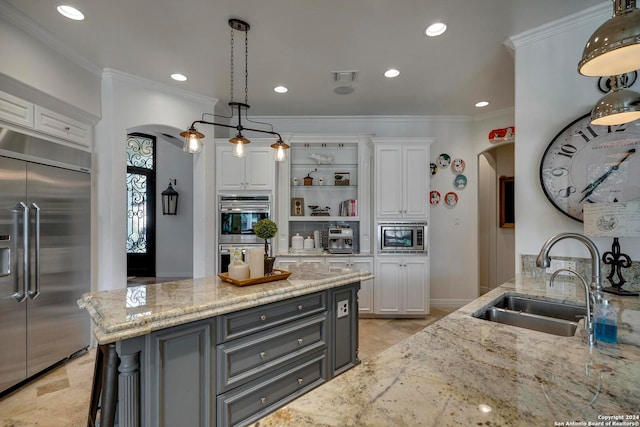 kitchen with white cabinets, light stone countertops, built in appliances, gray cabinets, and sink