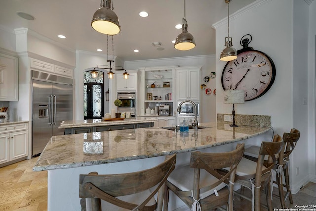 kitchen featuring sink, kitchen peninsula, decorative light fixtures, and stainless steel built in refrigerator