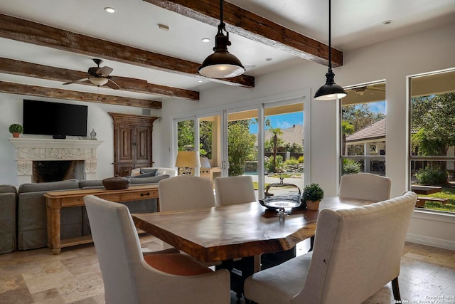 dining room featuring a fireplace, beam ceiling, and plenty of natural light