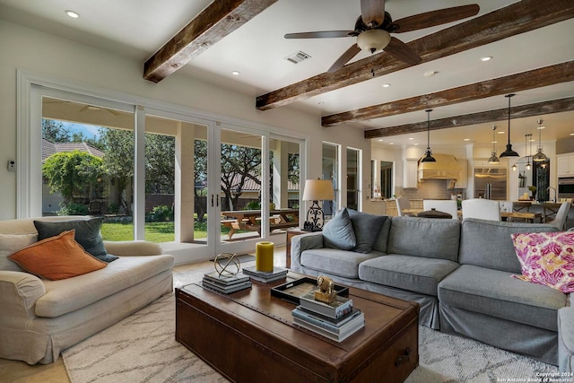 living room featuring beam ceiling, a healthy amount of sunlight, and ceiling fan