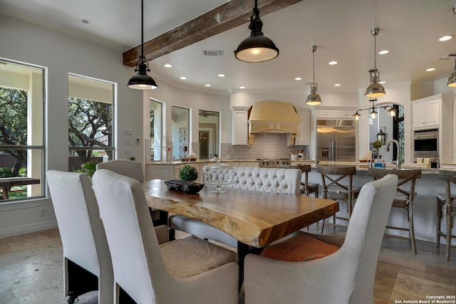 dining room with beam ceiling and sink