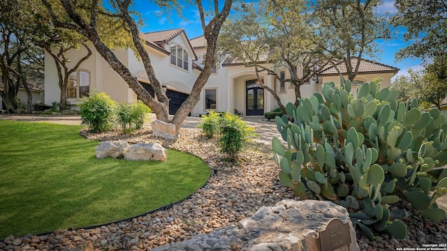 mediterranean / spanish-style house with french doors and a front lawn