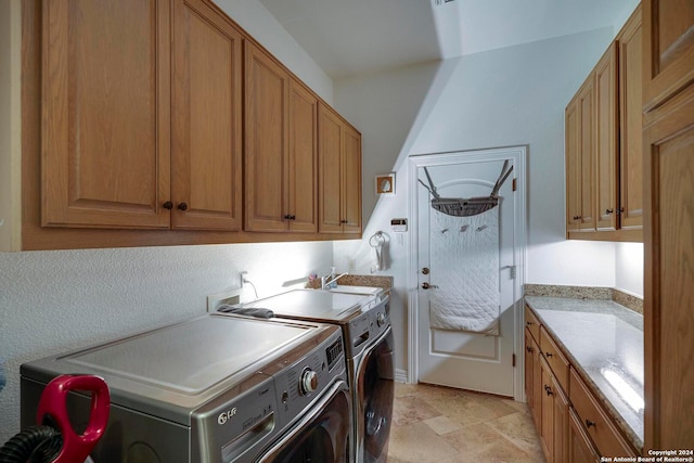 washroom with washing machine and dryer and cabinets