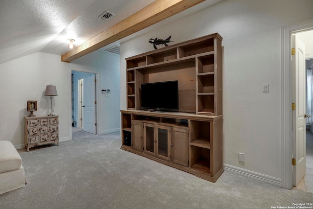 living room with a textured ceiling, vaulted ceiling, and light colored carpet