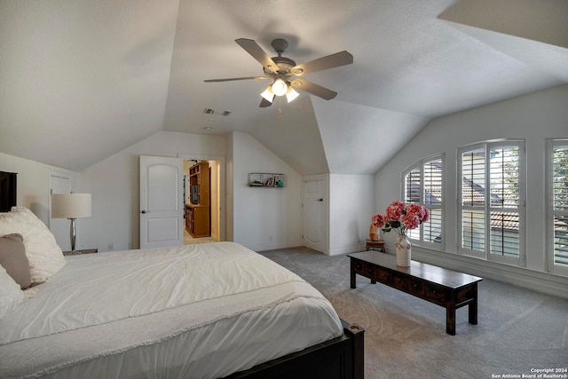 bedroom with a textured ceiling, ceiling fan, light colored carpet, and vaulted ceiling