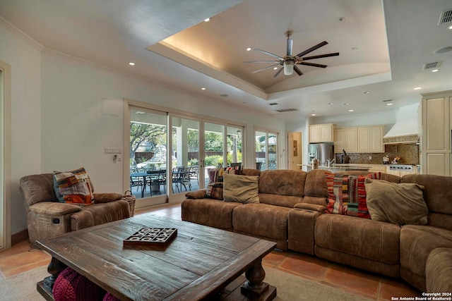 living room featuring ceiling fan, light tile patterned flooring, and a raised ceiling