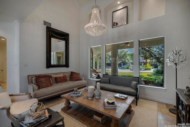 living room with a notable chandelier, ornamental molding, and a high ceiling