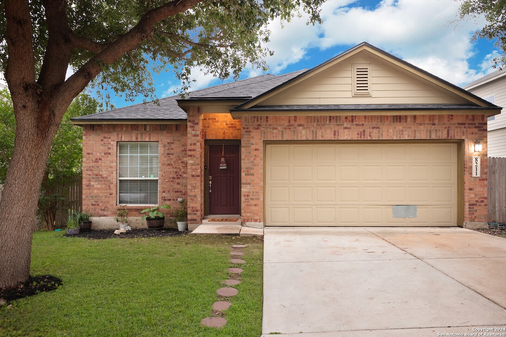 single story home featuring a garage and a front lawn