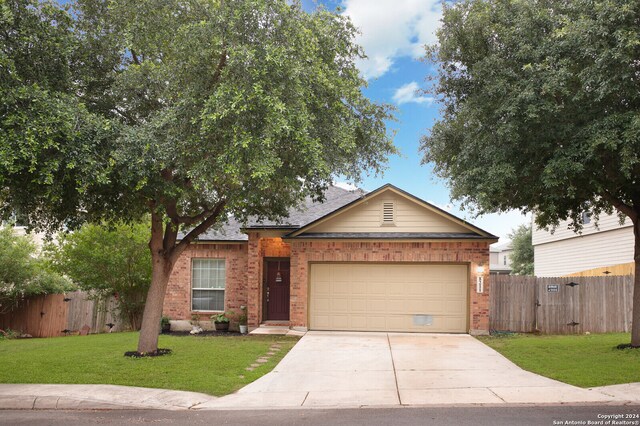 ranch-style home with a garage and a front lawn