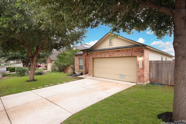 single story home featuring a garage and a front yard