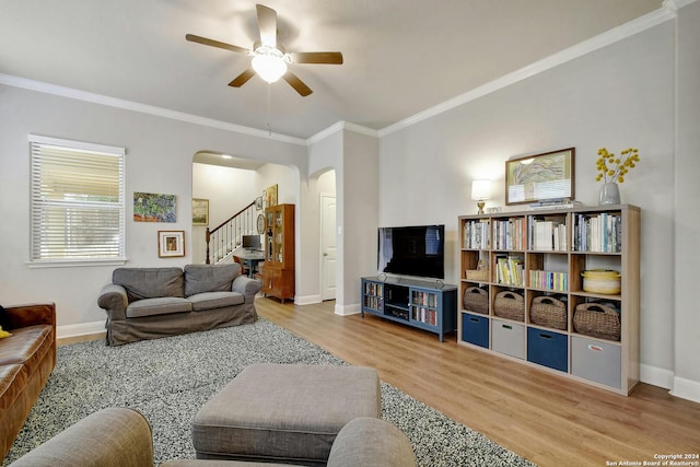 living room with light hardwood / wood-style floors, crown molding, and ceiling fan