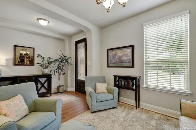 living area with light hardwood / wood-style flooring and a chandelier