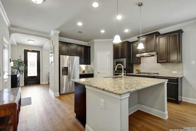 kitchen with light hardwood / wood-style flooring, tasteful backsplash, ornamental molding, appliances with stainless steel finishes, and decorative light fixtures