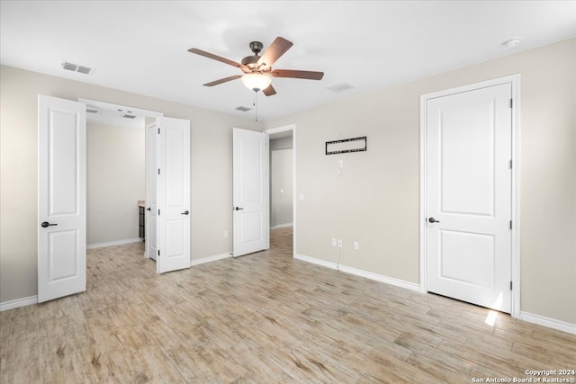 unfurnished bedroom with ceiling fan and light wood-type flooring