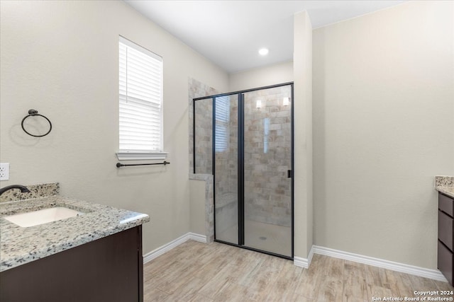 bathroom with walk in shower, hardwood / wood-style flooring, and vanity