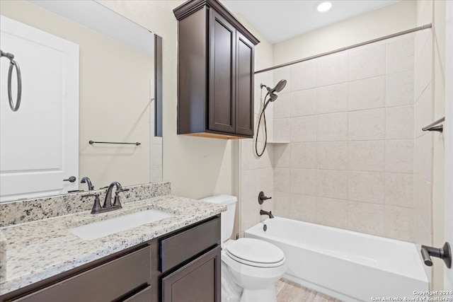 full bathroom featuring vanity, toilet, and tiled shower / bath combo