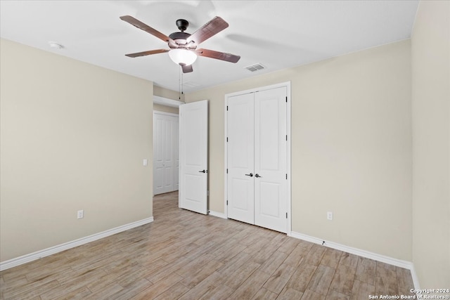 unfurnished bedroom with light hardwood / wood-style floors, a closet, and ceiling fan