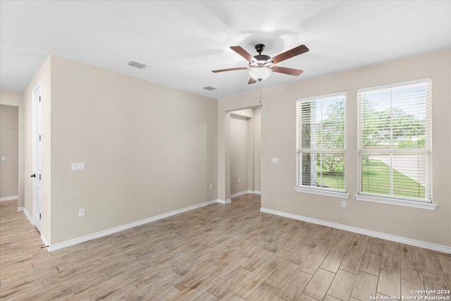 spare room with ceiling fan, a healthy amount of sunlight, and light wood-type flooring