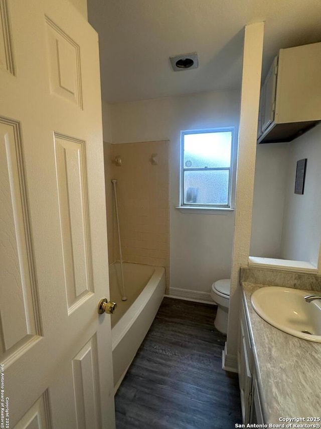 full bathroom featuring tiled shower / bath, hardwood / wood-style flooring, vanity, and toilet