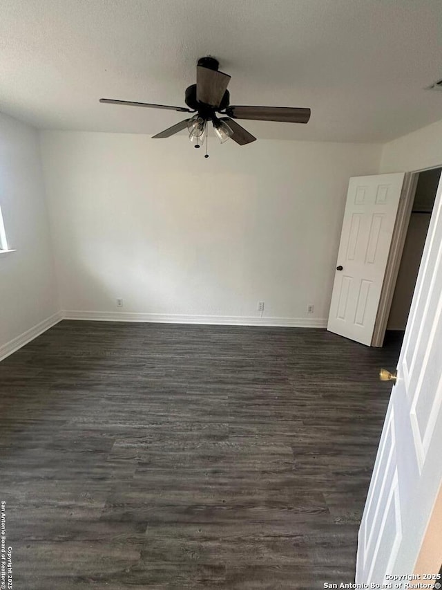 spare room with dark hardwood / wood-style floors and ceiling fan