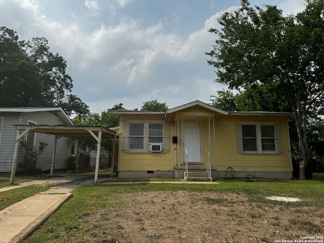 view of front of house with a front lawn and a carport