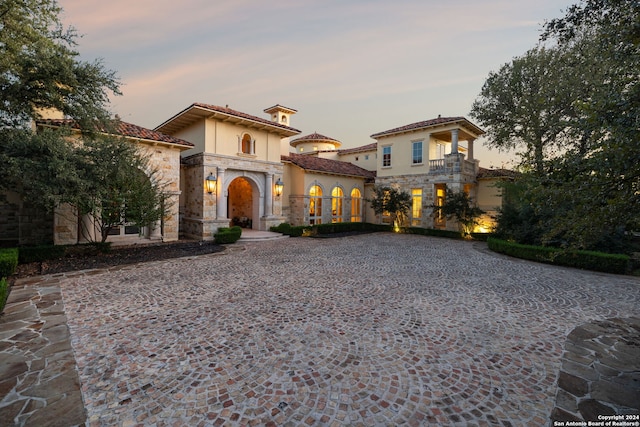 136 S Tower Hl, Country Village, TX 78232 - mediterranean / spanish-style house with stone siding, a balcony, curved driveway, and stucco siding