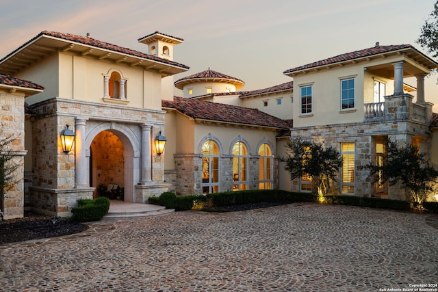 136 S Tower Hl, Country Village, TX 78232 - mediterranean / spanish house with stone siding, stucco siding, a tiled roof, and a balcony
