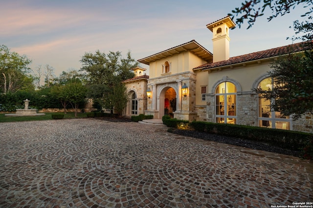 136 S Tower Hl, Country Village, TX 78232 - mediterranean / spanish-style home featuring a tiled roof, stone siding, stucco siding, and a chimney