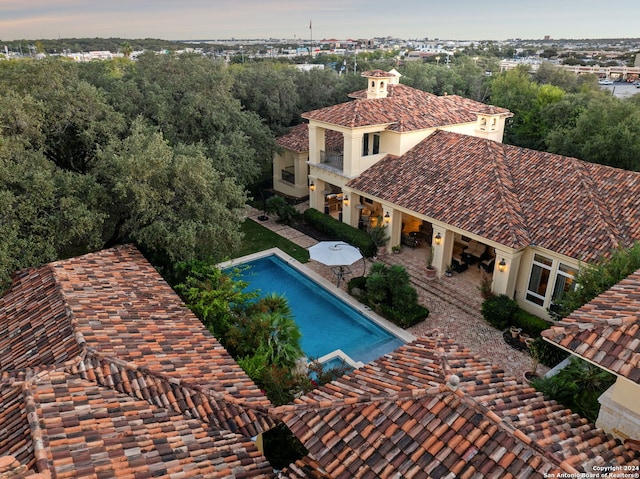 pool at dusk featuring a patio area