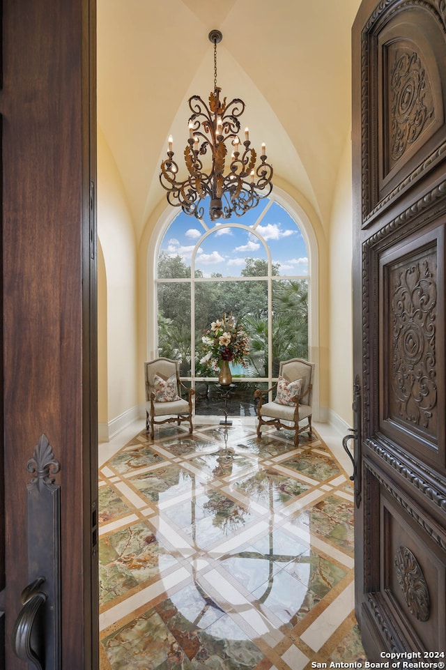 sitting room featuring a chandelier, high vaulted ceiling, and a healthy amount of sunlight