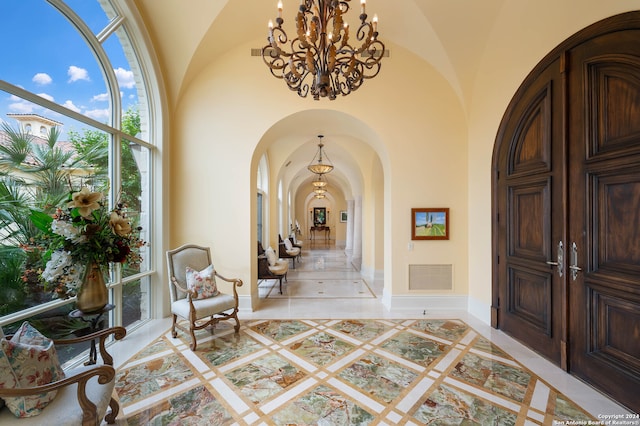 entryway with high vaulted ceiling and a notable chandelier