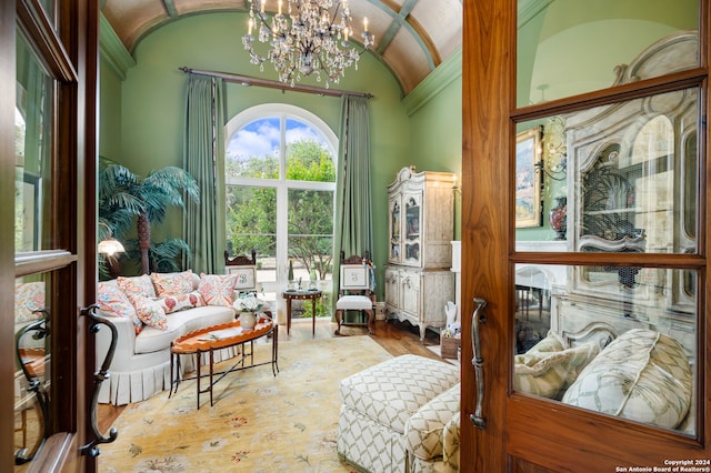 sitting room featuring hardwood / wood-style floors, lofted ceiling, and a notable chandelier