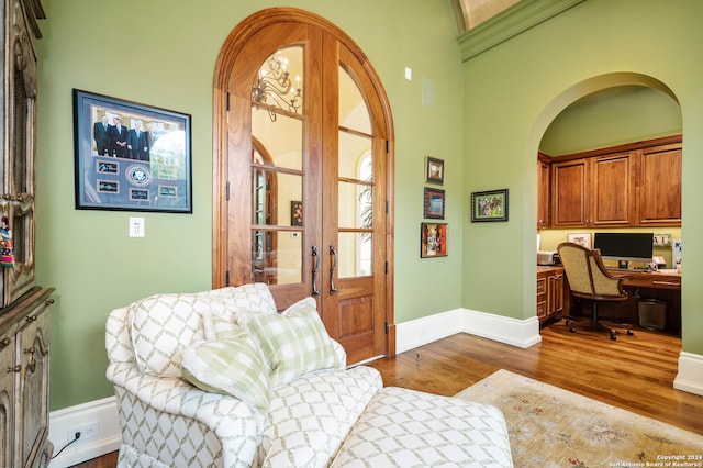 office featuring hardwood / wood-style floors, built in desk, and a high ceiling