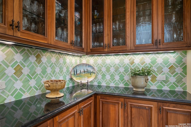 bar with decorative backsplash and dark stone countertops