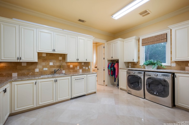 laundry area with sink, cabinets, separate washer and dryer, and ornamental molding