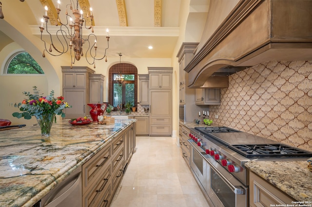 kitchen with custom range hood, tasteful backsplash, range with two ovens, and hanging light fixtures