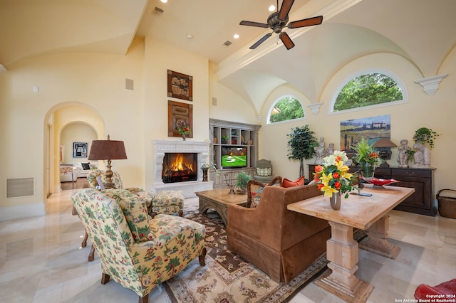 living room with ceiling fan and a towering ceiling