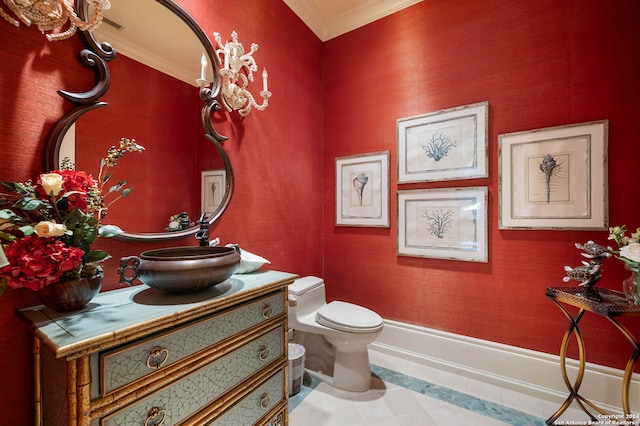 bathroom with toilet, vanity, and ornamental molding