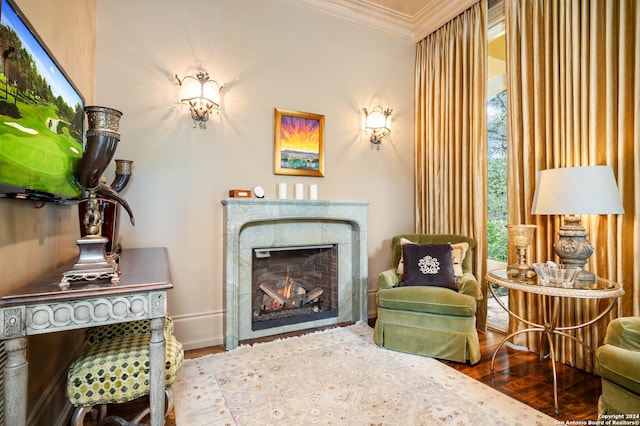 living area featuring hardwood / wood-style floors, crown molding, and a wealth of natural light