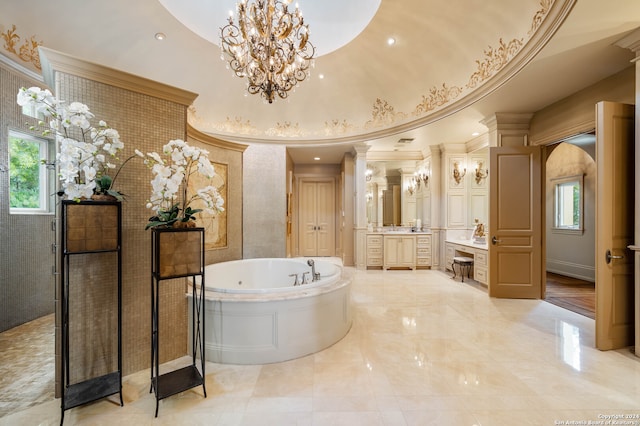 bathroom with ornate columns, a bathtub, vanity, and a healthy amount of sunlight