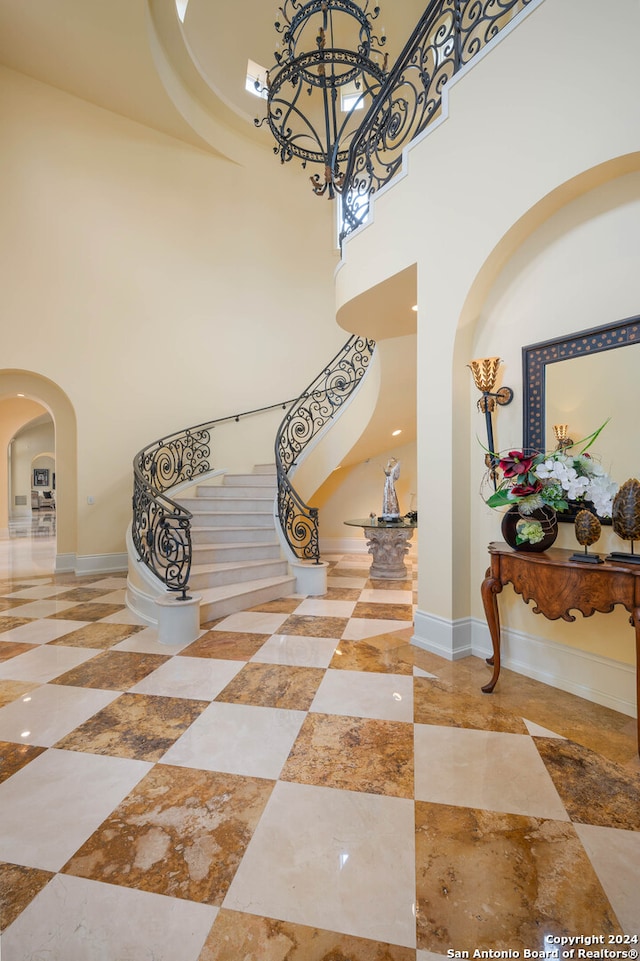 stairway featuring a towering ceiling