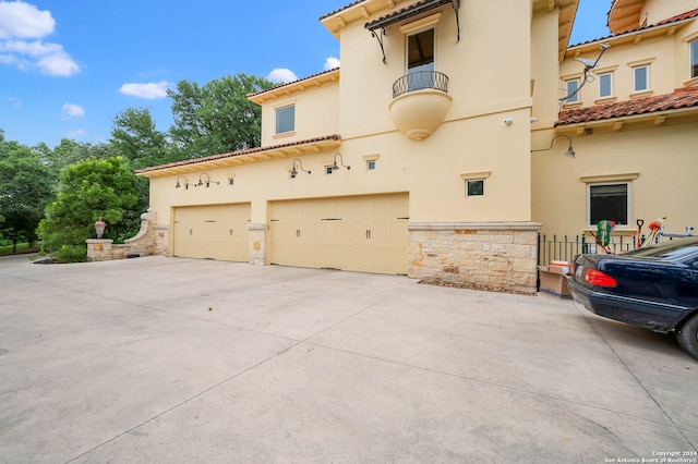 view of home's exterior with a garage and a balcony