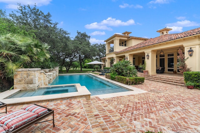 view of swimming pool with ceiling fan, a patio area, and an in ground hot tub