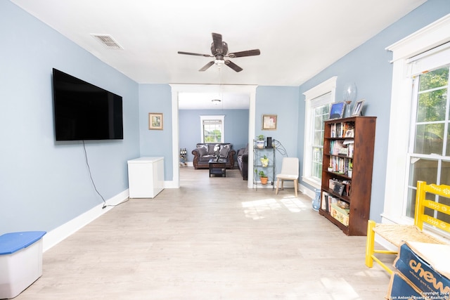 sitting room with a healthy amount of sunlight, ceiling fan, and light hardwood / wood-style flooring